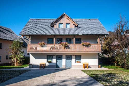 a large house with a balcony and two chairs at Apartments Francka in Bohinj