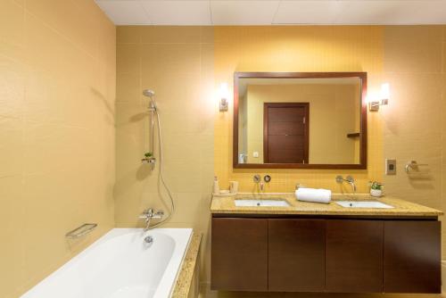 Tiara · Luxury Palm Jumeirah · Private Beach and Pool! في دبي: حمام به مغسلتين وحوض استحمام ومرآة