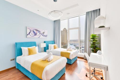 two beds in a room with a large window at Tiara · Luxury Palm Jumeirah · Private Beach and Pool! in Dubai