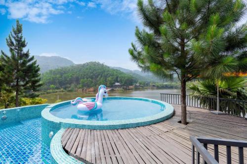 uma piscina com um golfinho de plástico na água em MyBinsu Villa - Venue Travel em Ba Vì