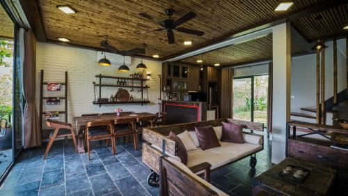 um alpendre com uma sala de jantar e uma cozinha em MyBinsu Villa - Venue Travel em Ba Vì