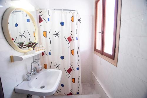 a bathroom with a sink and a shower curtain at Koukonas in Galaxidi