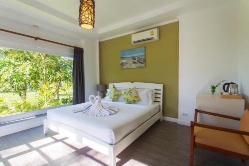 a bedroom with a bed and a large window at Panalee Koh Samui Resort - SHA Plus in Ban Bang Po
