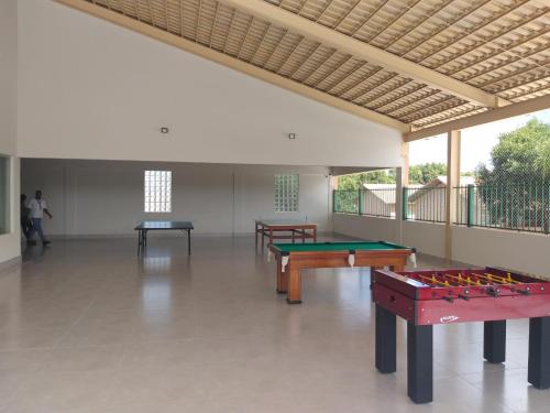 a room with three tables and a pool table at diRoma Fiori 89 com roupa de cama e banho. in Caldas Novas