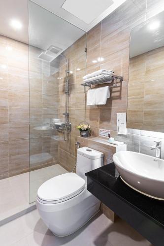 a bathroom with a toilet and a sink at Leela Orchid Hotel in Bangkok