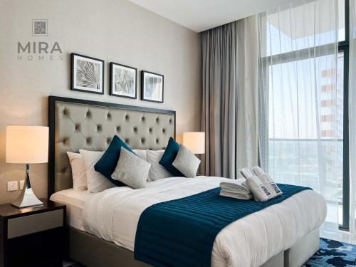 a bedroom with a large bed with a blue blanket at Mira Holiday Homes - Newly serviced apartment in Dubai South in Dubai