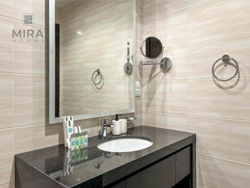 a bathroom with a sink and a mirror at Mira Holiday Homes - Newly serviced apartment in Dubai South in Dubai