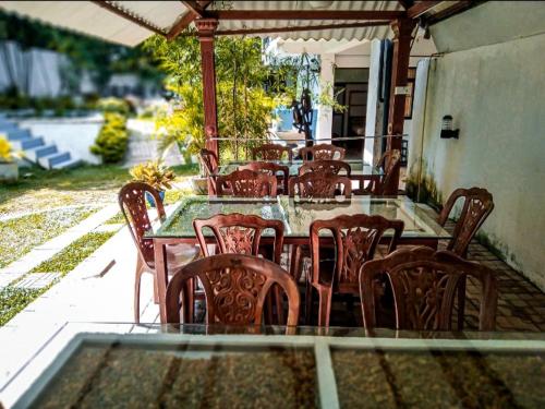 Une table et des chaises en bois sont disponibles sur la terrasse. dans l'établissement Elliot Nature Resort, à Galle