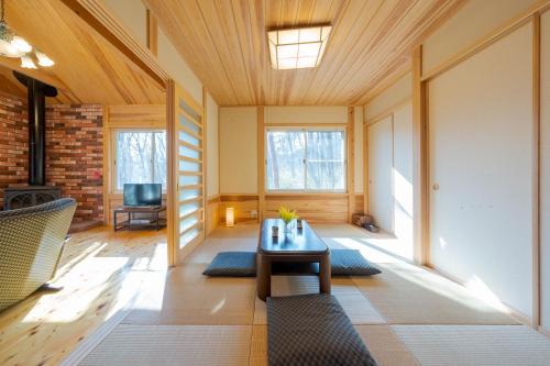 ein Wohnzimmer mit einem Tisch und einem Sofa in der Unterkunft スイートヴィラ 那須高原カシェット in Nasu