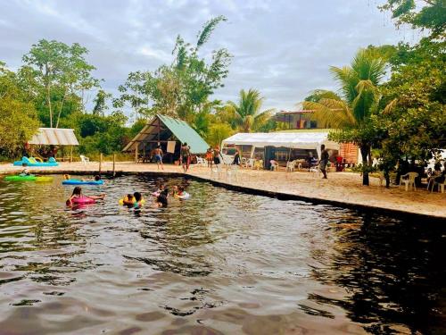 un groupe de personnes nageant dans un corps d'eau dans l'établissement Reset, à Zanderij