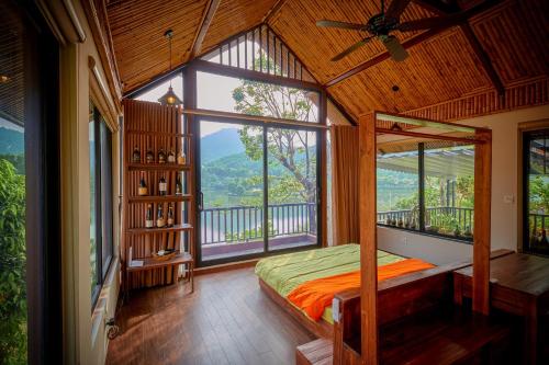 a bedroom with a bed and a large window at MyBinsu Villa - Venue Travel in Ba Vì
