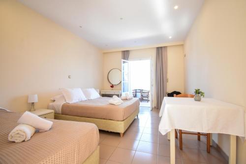 una camera d'albergo con due letti e un tavolo di Apollonia Hotel a Masouri