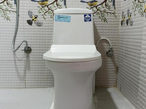 La salle de bains est pourvue d'une douche et de toilettes blanches. dans l'établissement Dubochaur Rest house & homestay, à Nagarkot