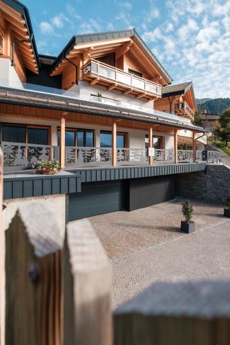 a house with a balcony and a fence at La Dila Dolomiti Mountain Lodge in Andalo