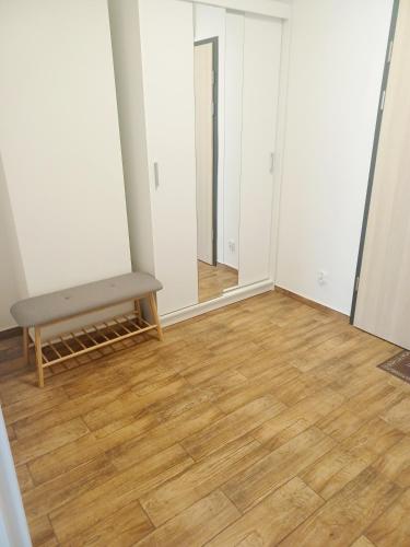 an empty room with a bench and a mirror at AJP Apartament Szczecin Dąbie in Szczecin
