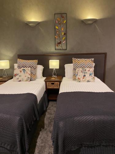 2 camas en una habitación de hotel con 2 lámparas en Chimes Spa Retreat, en Denmark