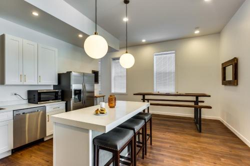 a kitchen with white cabinets and a island with bar stools at Converted Store Front Home Lets You Live Like a Local in the Heart of it All! condo in Chicago