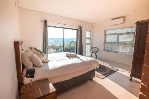 a bedroom with a large bed and a large window at Wolfkop Nature Reserve in Citrusdal