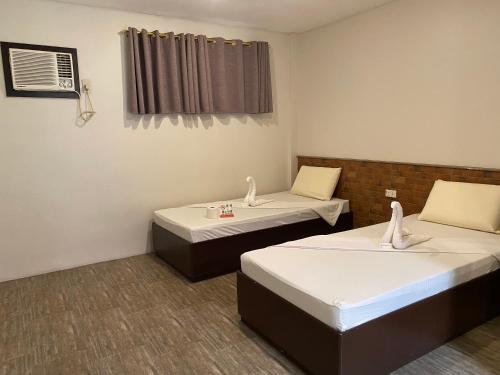 a room with two beds and a window at Traveler's Inn Bajada in Davao City