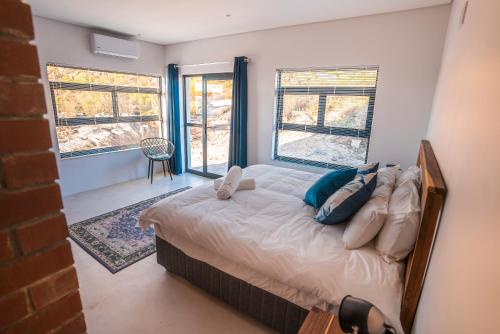 a bedroom with a bed in a room with windows at Wolfkop Nature Reserve in Citrusdal