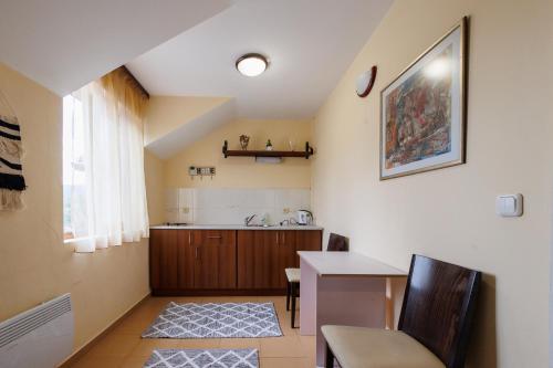 a living room with a table and a kitchen at Конна база и Къща за гости Дворене in Razlog