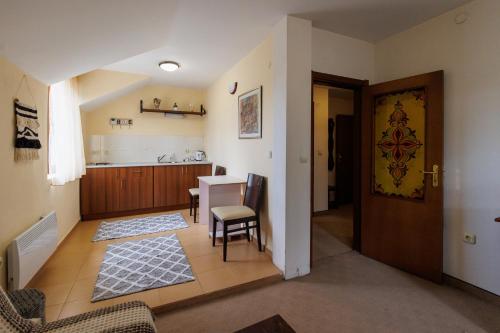 a living room with a table and a kitchen at Конна база и Къща за гости Дворене in Razlog