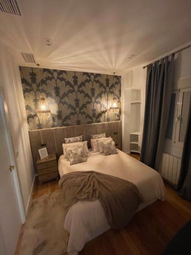una camera da letto con un grande letto con due cuscini di Apartamento cerca Plaza Mayor a Madrid