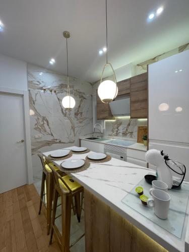 eine Küche mit einer großen Insel mit Stühlen und einer Arbeitsplatte in der Unterkunft Apartamento cerca Plaza Mayor in Madrid