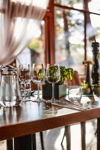 a wooden table with wine glasses on it at Hotel Sphinx in Żabia Wola