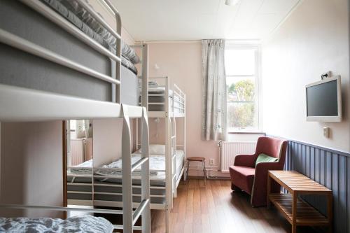 Habitación pequeña con literas y sofá en Kvibergs Vandrarhem - Hostel, en Gotemburgo