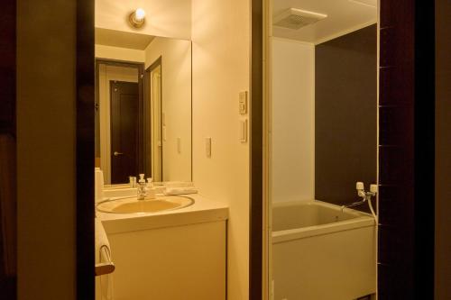 a bathroom with a sink and a bath tub at WPÜ HOTEL HAKONE in Hakone
