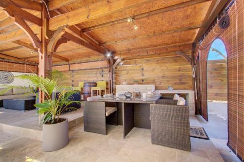 comedor con techos de madera, mesa y sillas en La Villa Alexie - Lagon de Trou d'Eau, en La Saline-Les-Bains