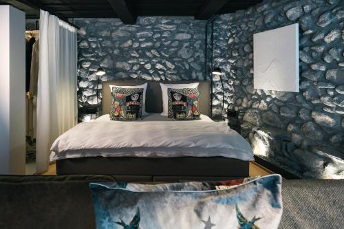 - une chambre avec un lit et un mur en pierre dans l'établissement Ferienresidenz von Planta, à Pratval