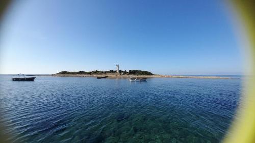 an island in the middle of the water with two boats at CASETTA RAFFO in Castellabate