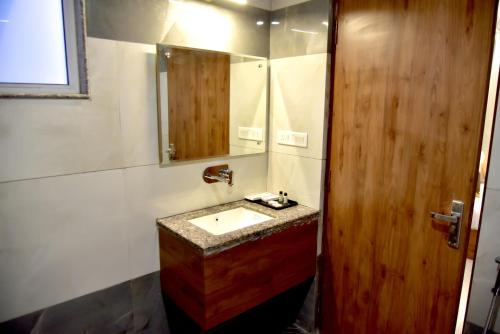 a bathroom with a sink and a mirror at Hotel Aarna in Jaipur