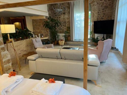 a living room with a couch and a tv at Hotel Finca Ca N'ai - Adults Only in Sóller