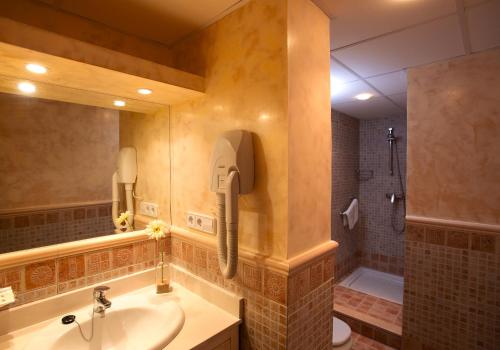 baño con lavabo y teléfono en la pared en Apartamentos Turísticos Los Patios, en Rota