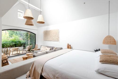1 dormitorio con 1 cama grande y 1 sofá en Suite-Suite luxury private guesthouse en Zandvoort