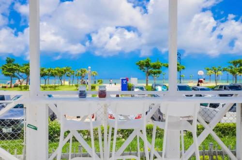 a table and chairs on a porch overlooking the beach at Araha Resort Arapana in Chatan