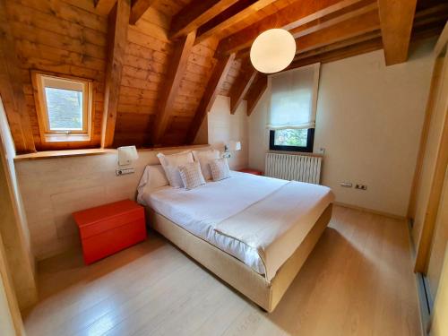 a bedroom with a large white bed and wooden ceilings at VIELHA X in Vielha