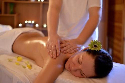 a woman getting a massage in a bed at Residence Hotel Balaton in Siófok