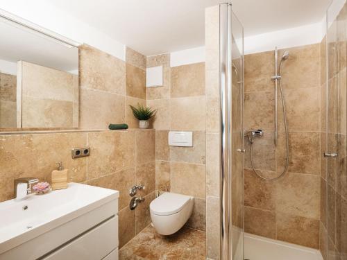 a bathroom with a shower and a toilet and a sink at Die Suttenhütte in Rottach-Egern