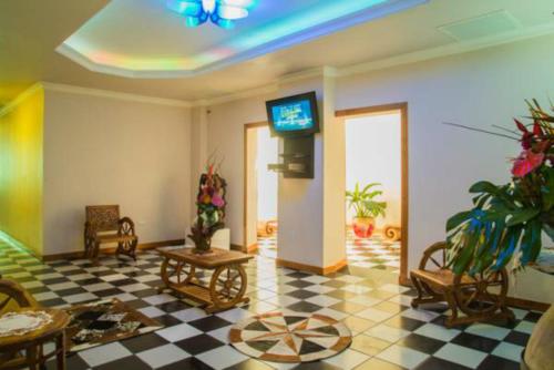 a living room with a tv and a checkered floor at My Hotel in Puerto Rico in San Juan