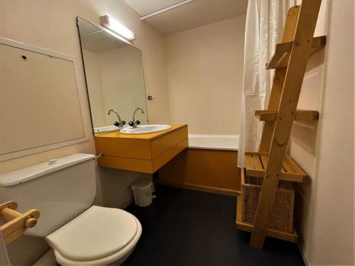 uma casa de banho com um WC, um lavatório e um espelho. em Studio Les Menuires, 1 pièce, 4 personnes - FR-1-452-52 em Les Menuires