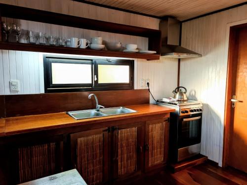 una cocina con fregadero y estufa en Cabañas 5 Sentidos, en Punta del Diablo