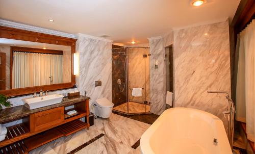 a bathroom with a tub and a sink and a shower at Venus Hotel Tam Đảo in Tam Ðảo