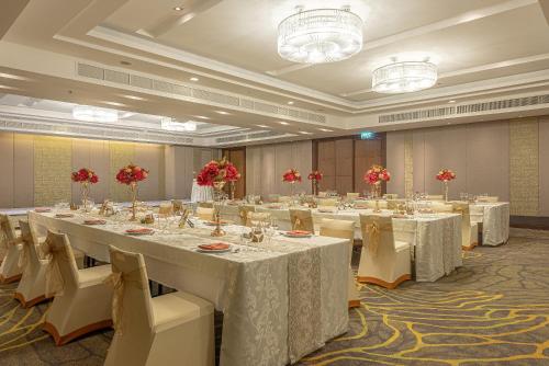 a large banquet room with white tables and chairs at Summit Windmill Golf Suite Hotel at Suvarnabhumi in Bangna