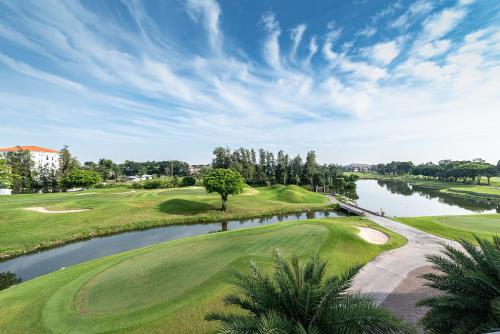 a view of a golf course with a pond at Summit Windmill Golf Suite Hotel at Suvarnabhumi in Bangna