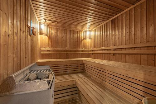 an empty wooden sauna with a tub in it at Summit Windmill Golf Suite Hotel at Suvarnabhumi in Bangna