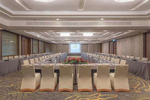 a conference room with a long table and chairs at Summit Windmill Golf Suite Hotel at Suvarnabhumi in Bangna